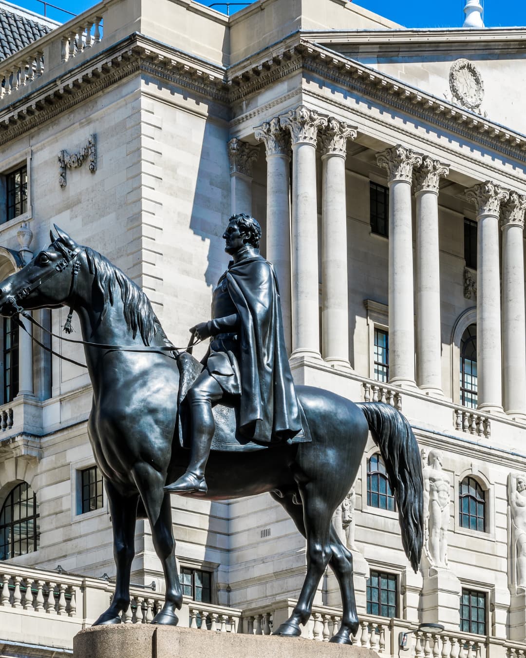 An equestrian statue in front of a columned building in the City of London
